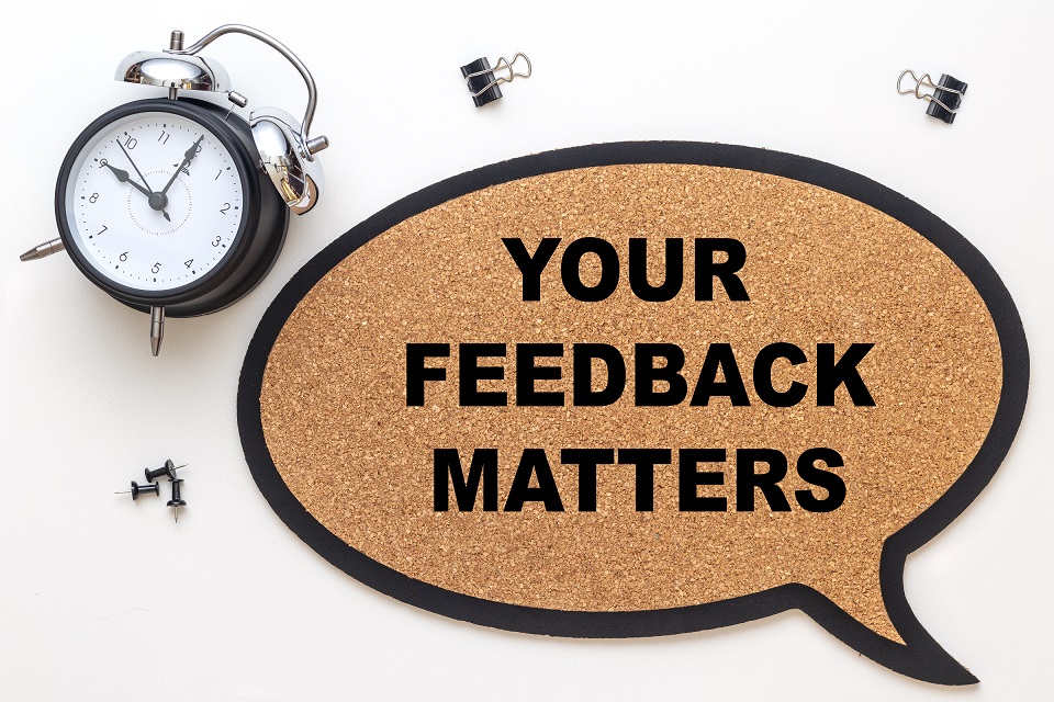 Your feedback matters on suberic balloon and isolated over white background with black alarm clock. Business concept.