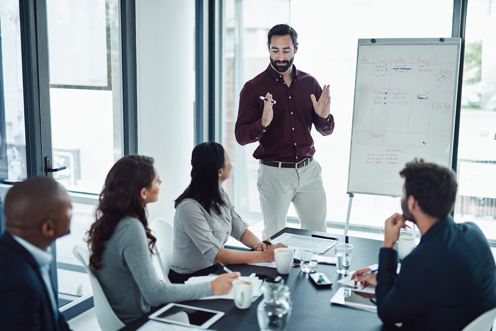 Shot of a businessman delivering a presentation to his coworkers in the boardroom of a modern office CRM-Consultant-Richmond-Hill